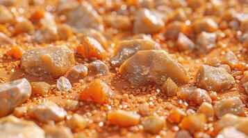 Close-up view of amber and agate stones. Many small and large amber and agate pieces, with various shapes and sizes, displayed on a textured orange surface. photo