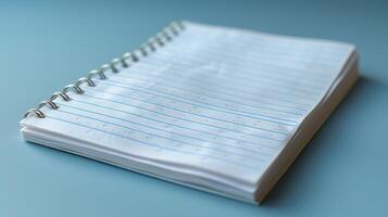 Blank spiral-bound notebook on a light teal surface. photo
