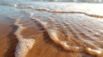 Shallow water and sand at the beach. Waves washing over wet sand. Close-up view. Sunlight on water. photo