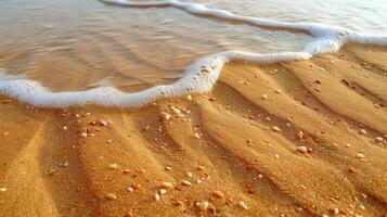 Gentle ocean waves lapping onto a sandy beach, with small shells and pebbles embedded in the wet sand. photo