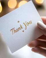 Hands Gently Holding Elegant Gold Embossed Thank You Card with Soft Lighting in Magazine Style photo