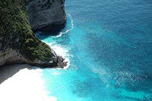 Beautiful landscape aerial view of cave of cliff rocky at the sea with foam waves and splash water of Keling king beach and ocean of Bali, Indonesia photo