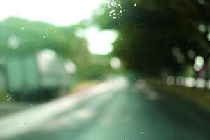 Blurred view of greenery outside on windshield background photo