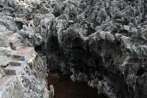 Ancient concrete stair and path for hike on rocky cliff and grand stone mountain in sea and river of Bali, Indonesia photo