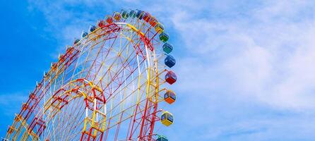 The majestic Ferris wheel stands against the clear blue sky. Panoramic view. photo