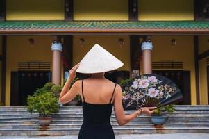 A tourist woman in a Non La hat on the background of beautiful landscapes at the Linh Ung Son Tra pagoda in Da Nang. photo