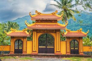 The gate to the entrance of a Buddhist temple in Asia against the backdrop of mountains. photo
