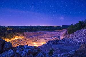 A large open pit with a night sky in the background photo