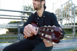 Hand Of MAn Turns Wrench For Manual Tuning Of Classical Guitar photo