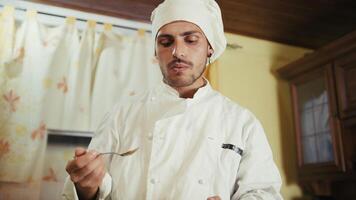 Private Home Chef Tasting His Tomato Sauces With a Spoon photo