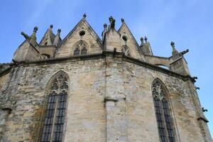 Exterior of a Gothic cathedral with gargoyles and stained glass windows. photo