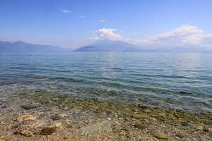 Picturesque view of a clear lake with mountains in the background. photo