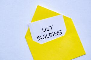 List building text on white notepad inside a yellow envelope. Making money online concept photo