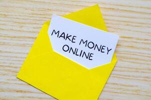 Make Money Online text on white notepad inside a yellow envelope. Making money online concept photo