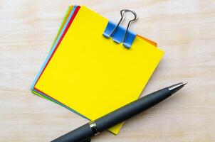 Top view of yellow notepad and pen with customizable space for text photo