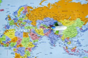 Top view of small toy airplane on a world map representing travel and destination concept photo