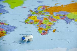 Top view of small toy airplane placed on a world map representing travel or global exploration. Travel and destination concept photo