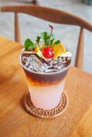 a drink with ice and garnish on top of a wooden table photo