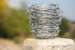Roll of barbed wire. Outdoor background. Concept, construction tool. Barbed wire is used for make fences , secure property ,make border to show the territory of area. photo