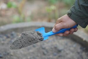 Hand held trowel of sample soil in garden. Concept, soil quality inspection, research and development for agriculture product. Find the best from different soil type and source photo