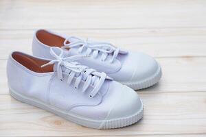 Pair of new trendy white canvas sneakers. Comfortable, fashionable style. Concept, shoes for doing sport or exercise also can wear for traveling, hiking or doing active activity. photo