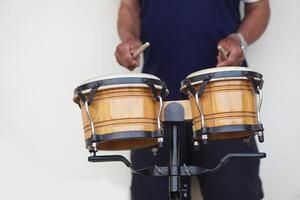 Man is beating the bongo drums. Concept, musical percussion instrument for rhythm of music to make more fun for performing or dancing. Beat drum with rhythm along music and songs. photo