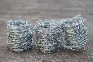 Rolls of metal barbed wire. Concept, construction tool. Barbed wire is used for make fences , secure property ,make border to show the territory of area. photo