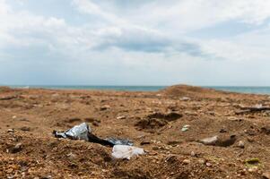 Plastic bottles on the sandy beach. Environmental pollution photo