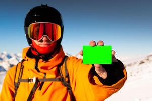 Ski pass with copy space in hand of skier with mountain range in background. Concept for illustration of entrance fee for winter sport photo