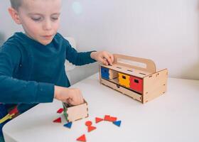 The shapes are scattered across the table, a perfect Montessori activity for developing coordination. photo