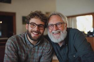 A man with glasses and a beard is smiling next to his father photo