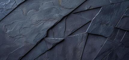 A black stone wall with a pattern of different shapes photo