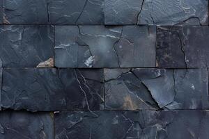 Dark gray stone wall, textured paving. Close-up view of rectangular, interlocking slabs photo
