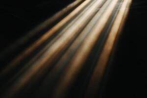 Golden rays of light piercing darkness photo