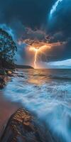 Lightning storm over the ocean with a tree in the foreground photo