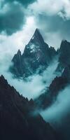 A mountain range with clouds and fog over it photo