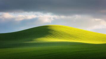 A green hill with a dark sky photo