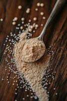 Psyllium husk on wooden surface with silver spoon photo