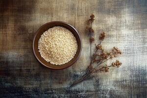 Psyllium seeds in a bowl with dry plants on wooden surface photo