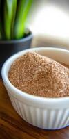 Psyllium husk powder in a white bowl with greenery photo