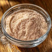 Psyllium husk in a clear bowl on a wooden surface photo