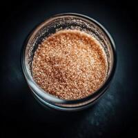Brown psyllium in a glass jar on a dark surface photo