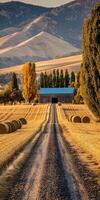 Rolling hills at sunset with a barn and hay bales photo