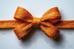 Rustic Orange Yarn Bow on White Background for Craft and Design Projects photo