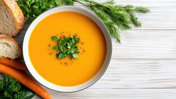 bowl of fresh vegetable soup with herbs and crusty bread nearby photo