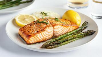 Delicious baked salmon with asparagus, lemon, and creamy rice photo