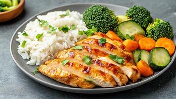 Delicious chicken teriyaki served with rice and steamed vegetables photo
