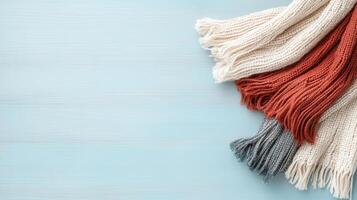 Cozy scarves in red, white, and gray on light blue background photo