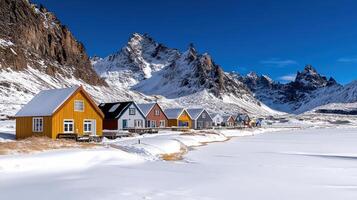 Colorful houses line the shore of a snowy mountain range photo