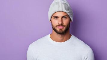 A man in a white t - shirt and beanie on a purple background photo